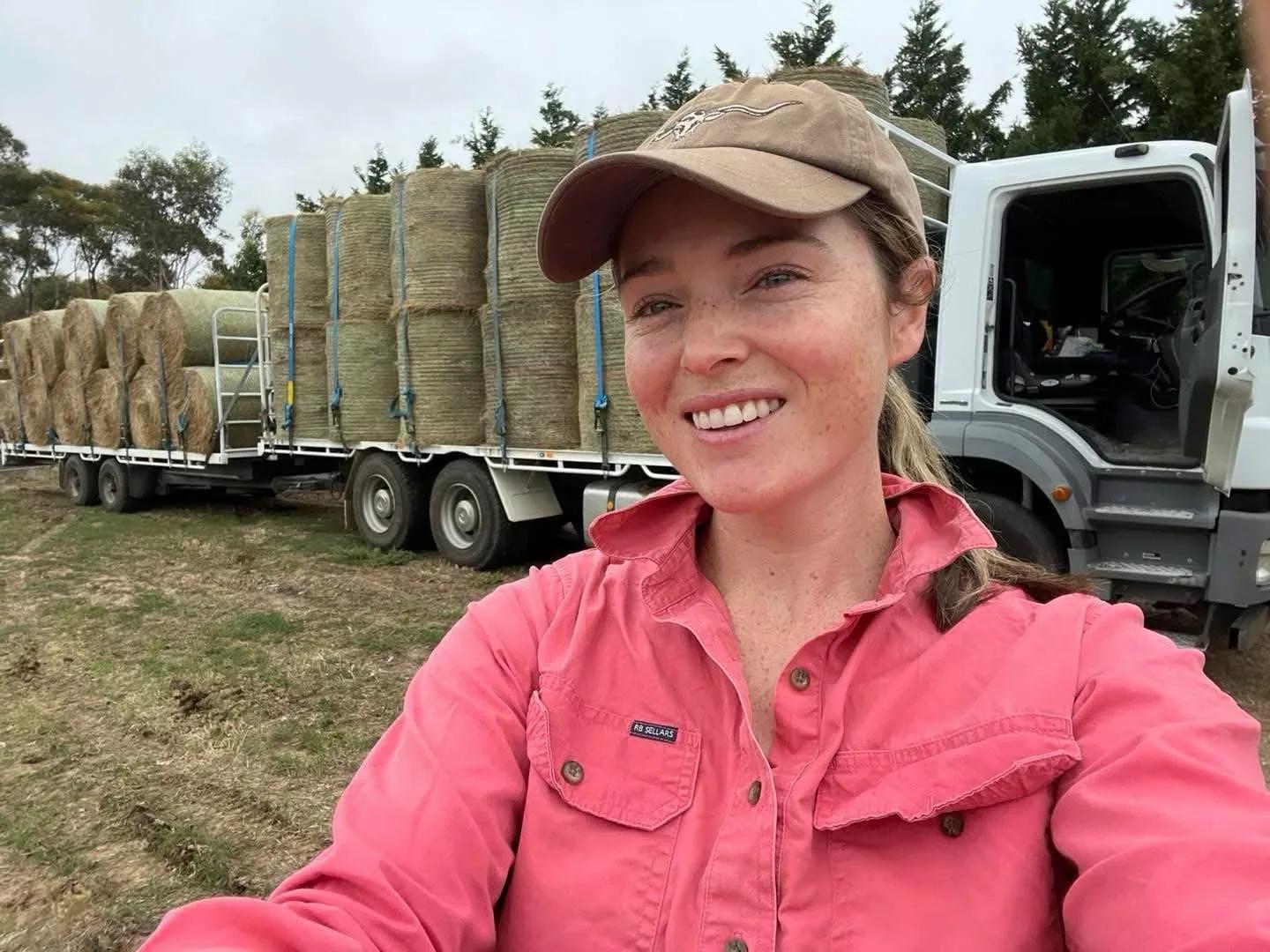 Ash in front of a loaded hay truck and trailer in the paddock